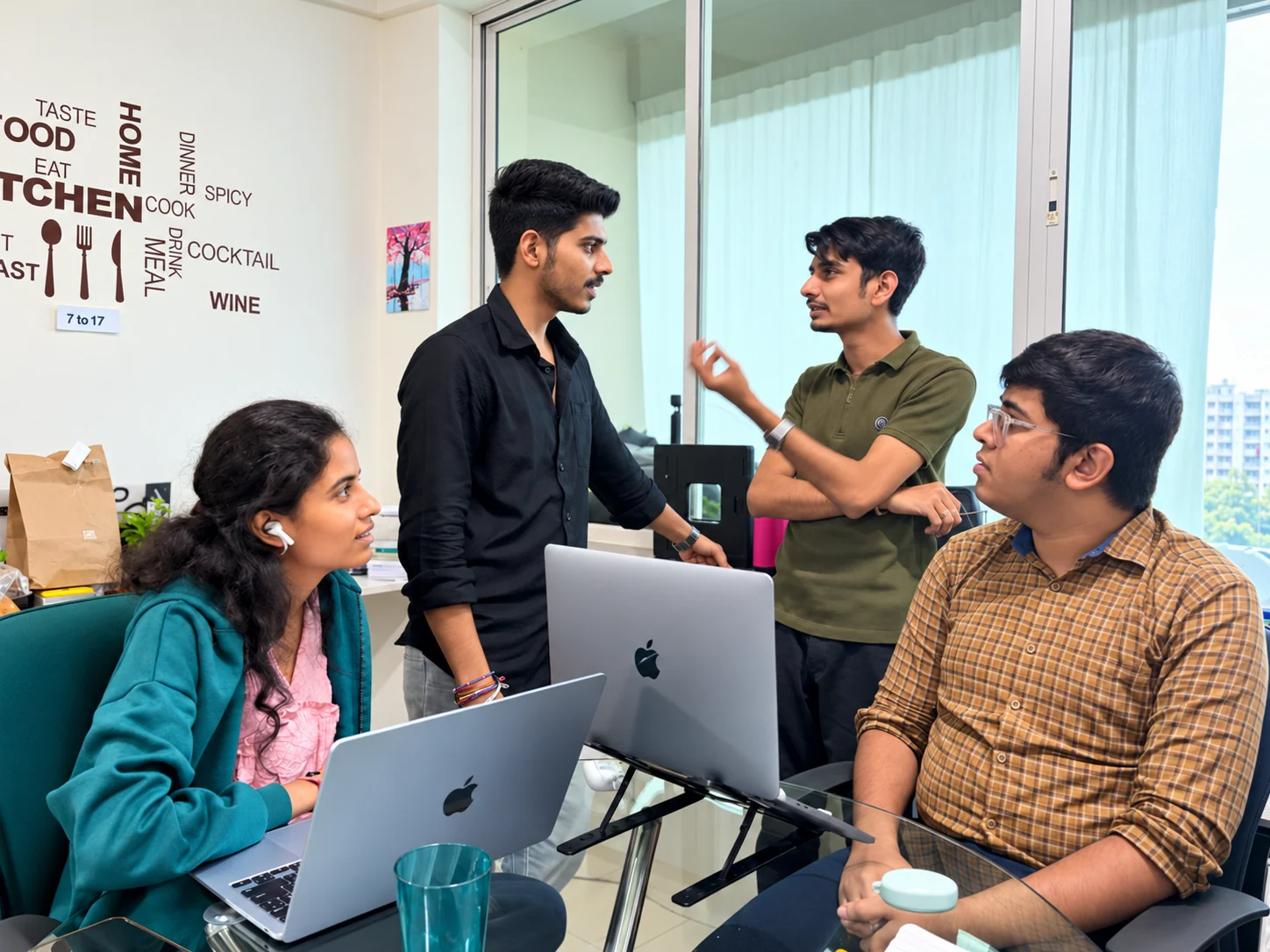 Four teammates discussing a website project around their laptops